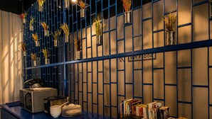 A blue counter with a microwave, plates, and books. - Loftel Station Hostel (Bangkok)