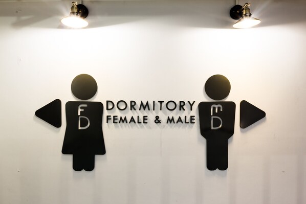 A wall with dormitory signs for female and male rooms.