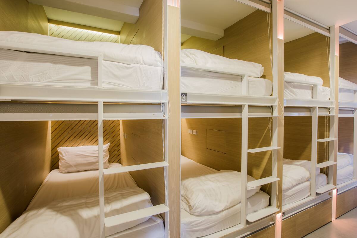A bunk bed room with wooden headboards and white bedding.