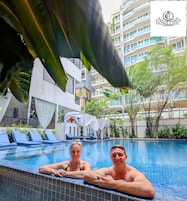 Una piscina al aire libre, sillones reclinables de piscina