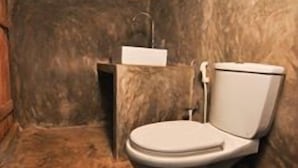 Une salle de bain avec des toilettes blanches, un meuble en bois et un lavabo.