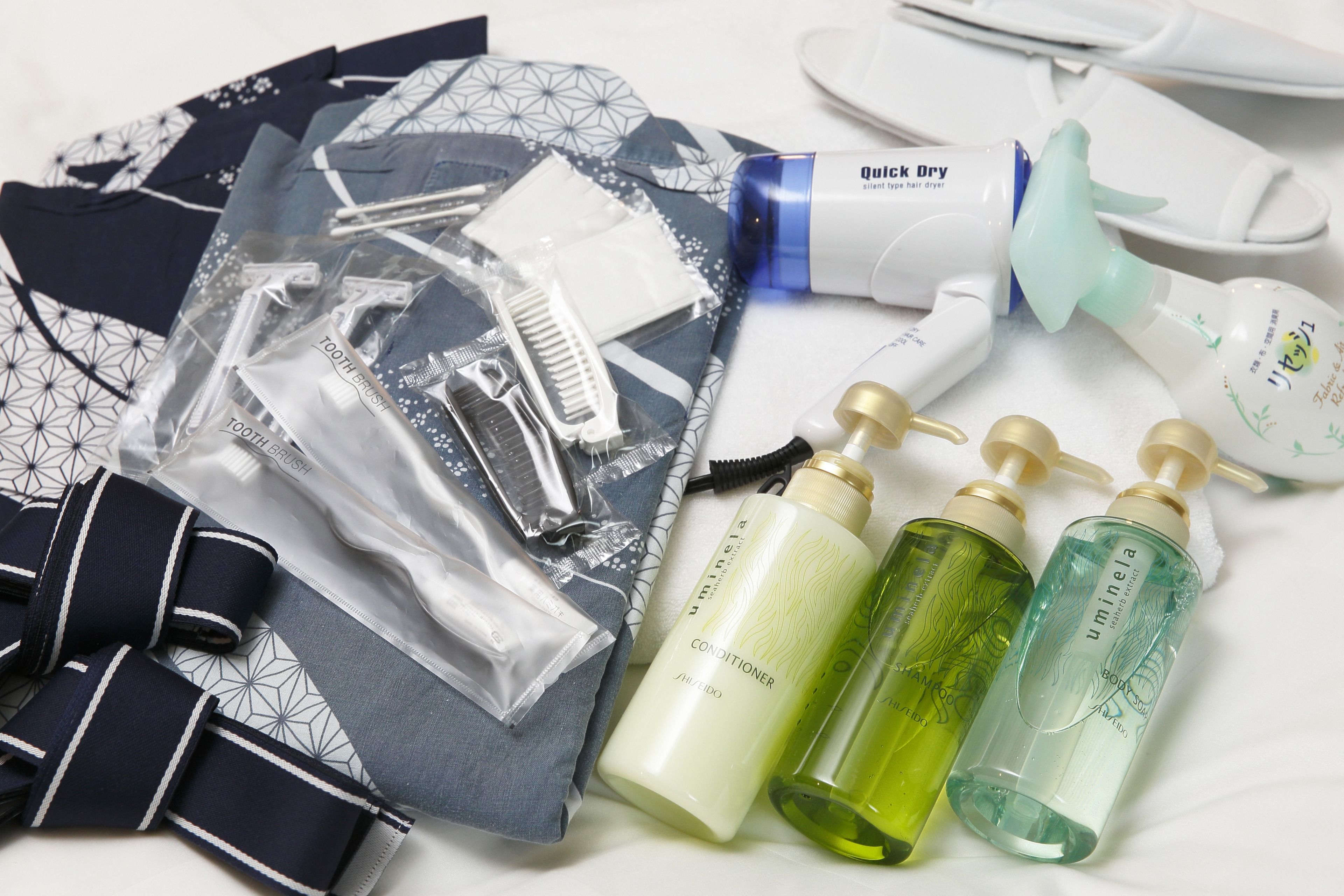 Une collection de produits de toilette comprenant un sèche-cheveux, des peignes et divers produits d’hygiène personnelle.