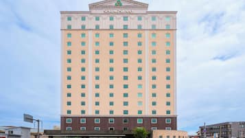 A tall hotel building with a central entrance and multiple floors.