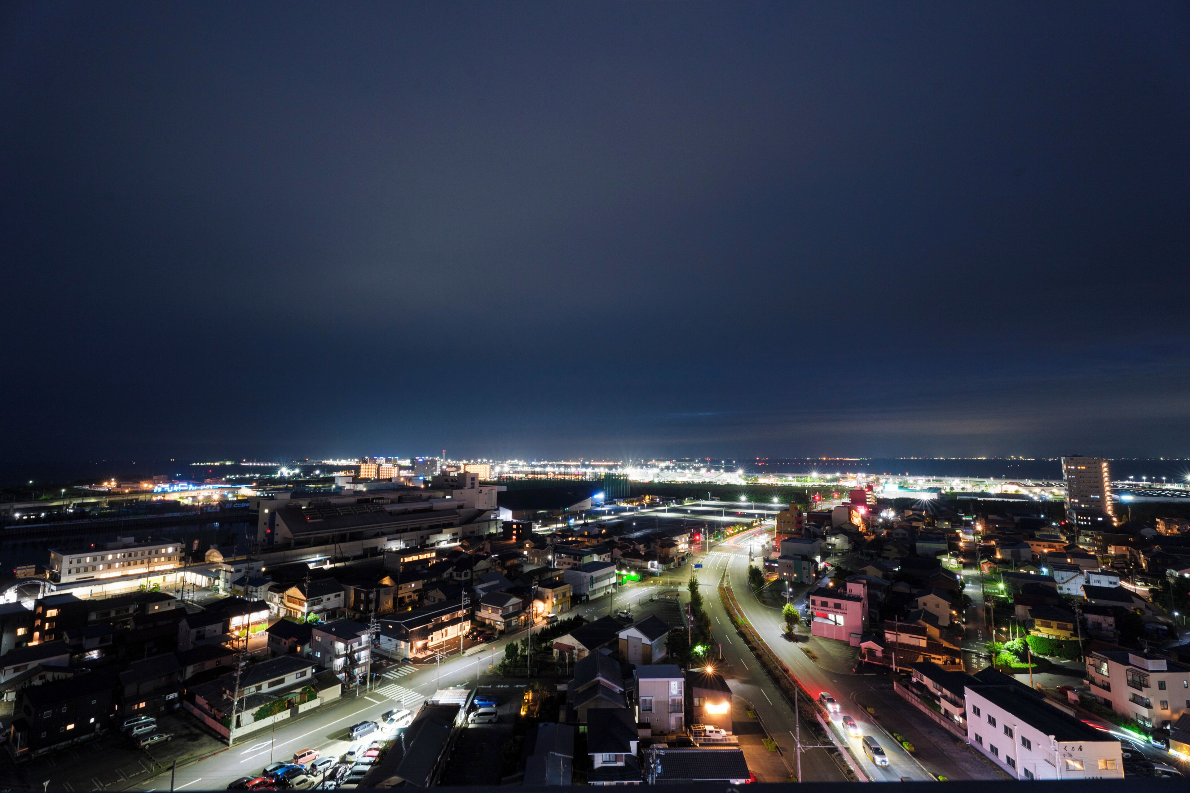 A nighttime cityscape with illuminated buildings and roads.