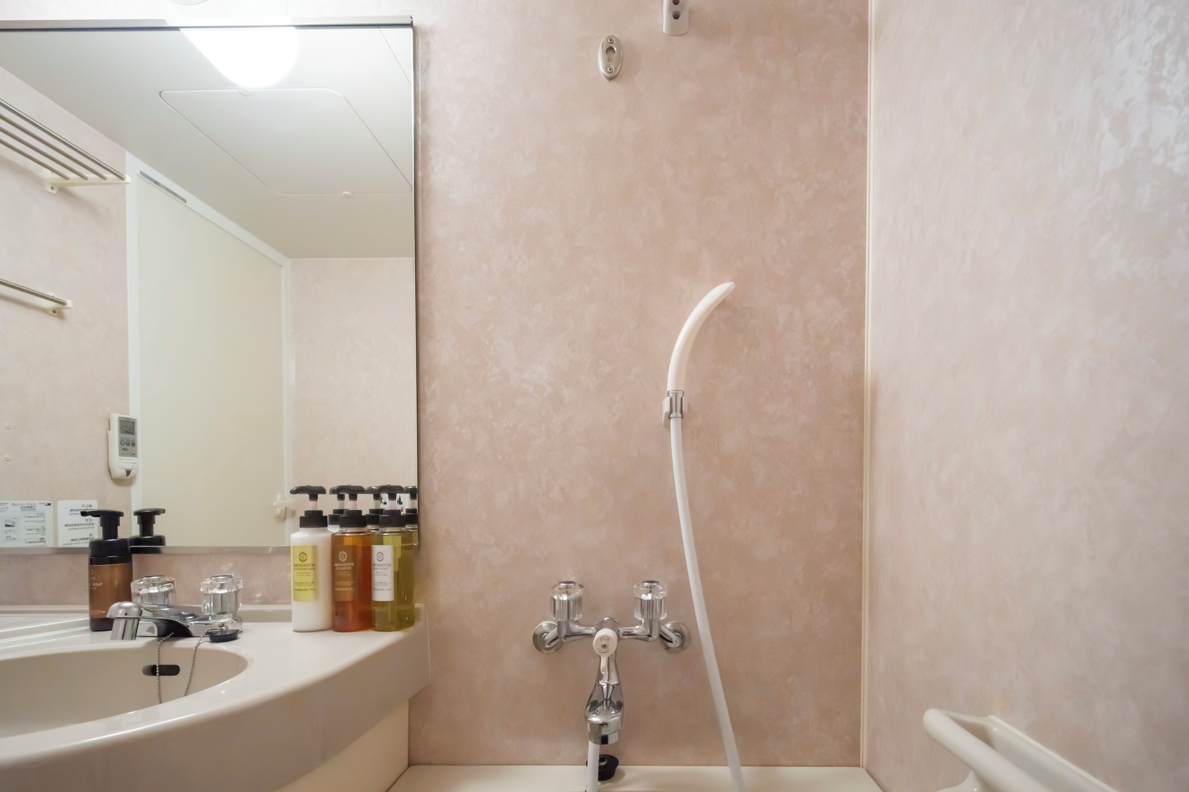 Un bagno con lavandino, specchio, articoli da toilette e doccia.