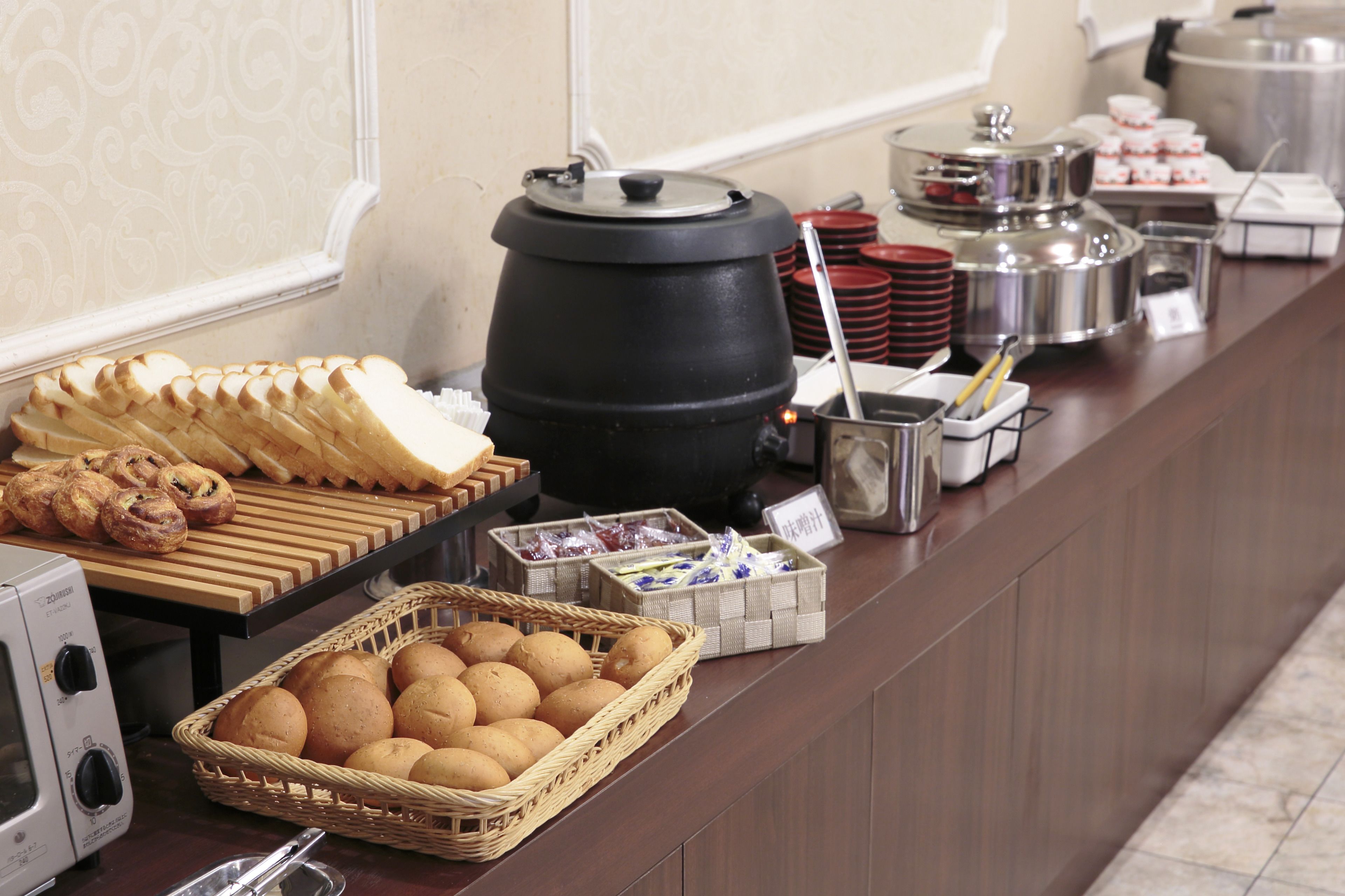 Ein reichhaltiges Buffet mit Brot, Gebäck und verschiedenen Speisebehältern.