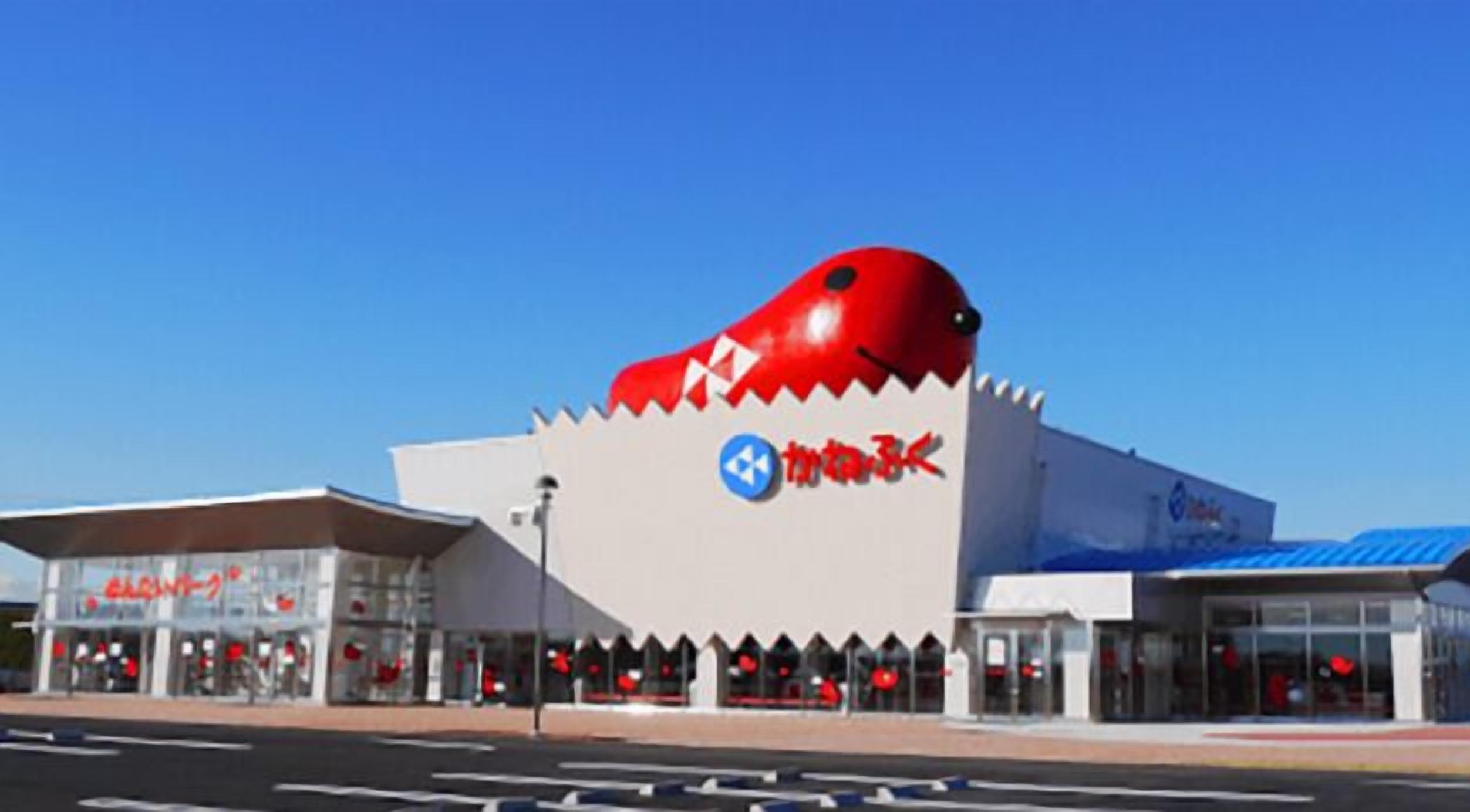 A building with a distinctive red and white design, featuring a large red shape on the roof and a blue logo with red text.