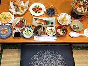 Una mesa de comedor con diferentes platos y un mantel individual.