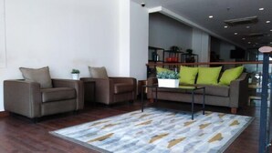 A modern living room with two sofas, a coffee table, and a patterned rug. - Sare Hotel (Jakarta)