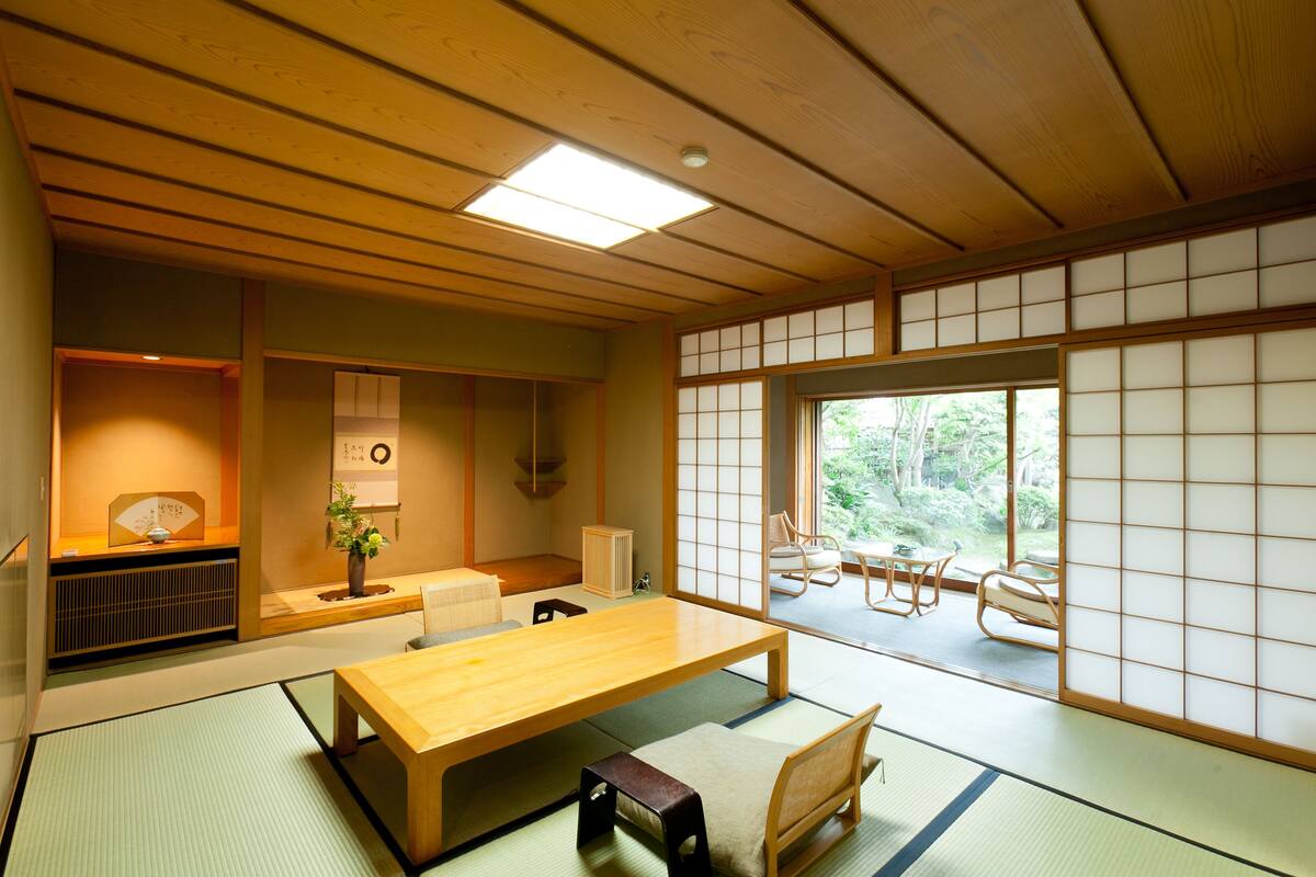 A traditional Japanese room with tatami flooring, a low wooden table, and sliding shoji doors.