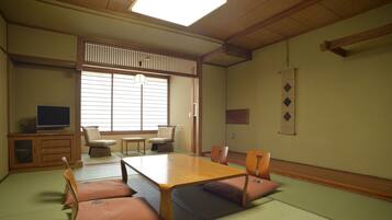 A traditional Japanese room with tatami flooring, a low wooden table, and tatami mats.