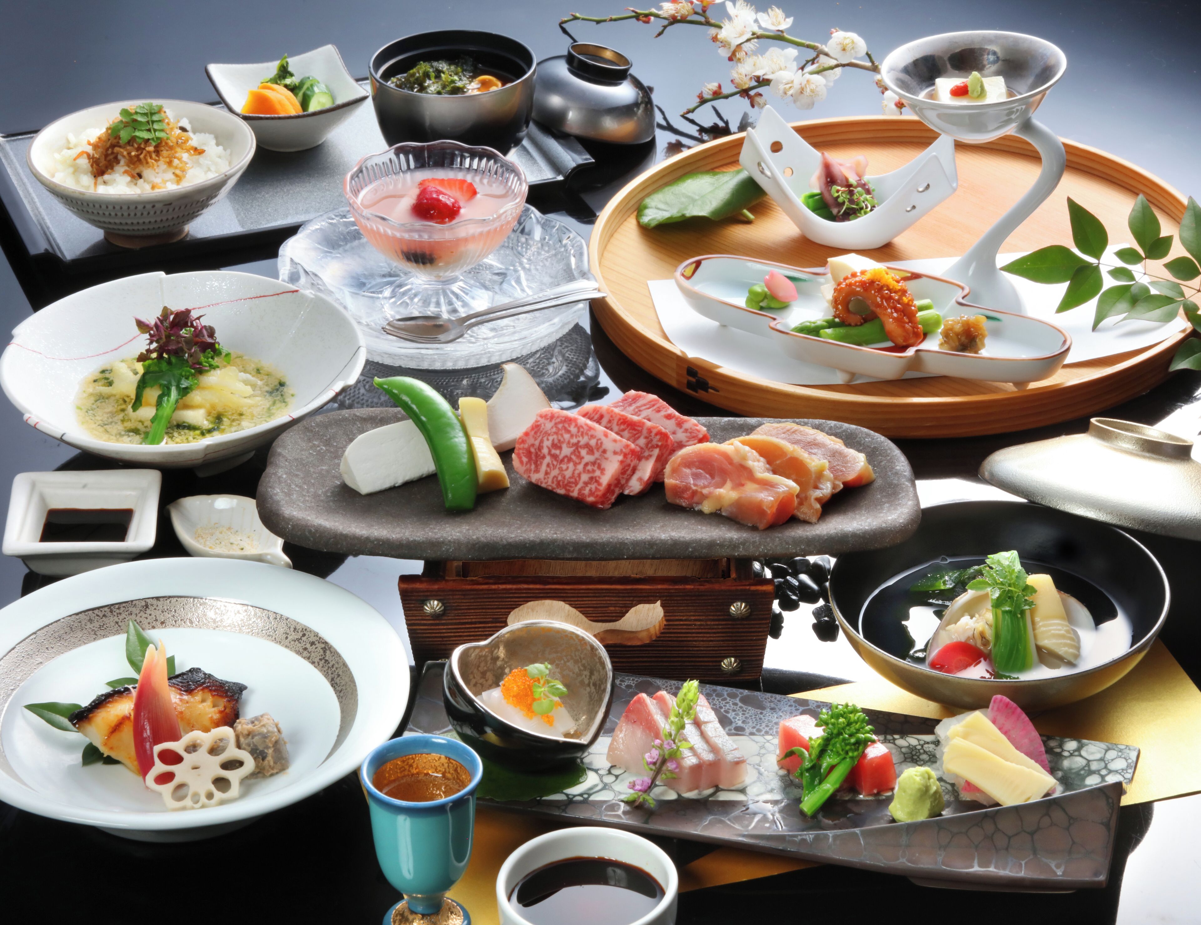 Eine Auswahl an Gerichten auf einem Tisch, darunter Sushi, Sashimi und weitere Speisen der asiatischen Küche.