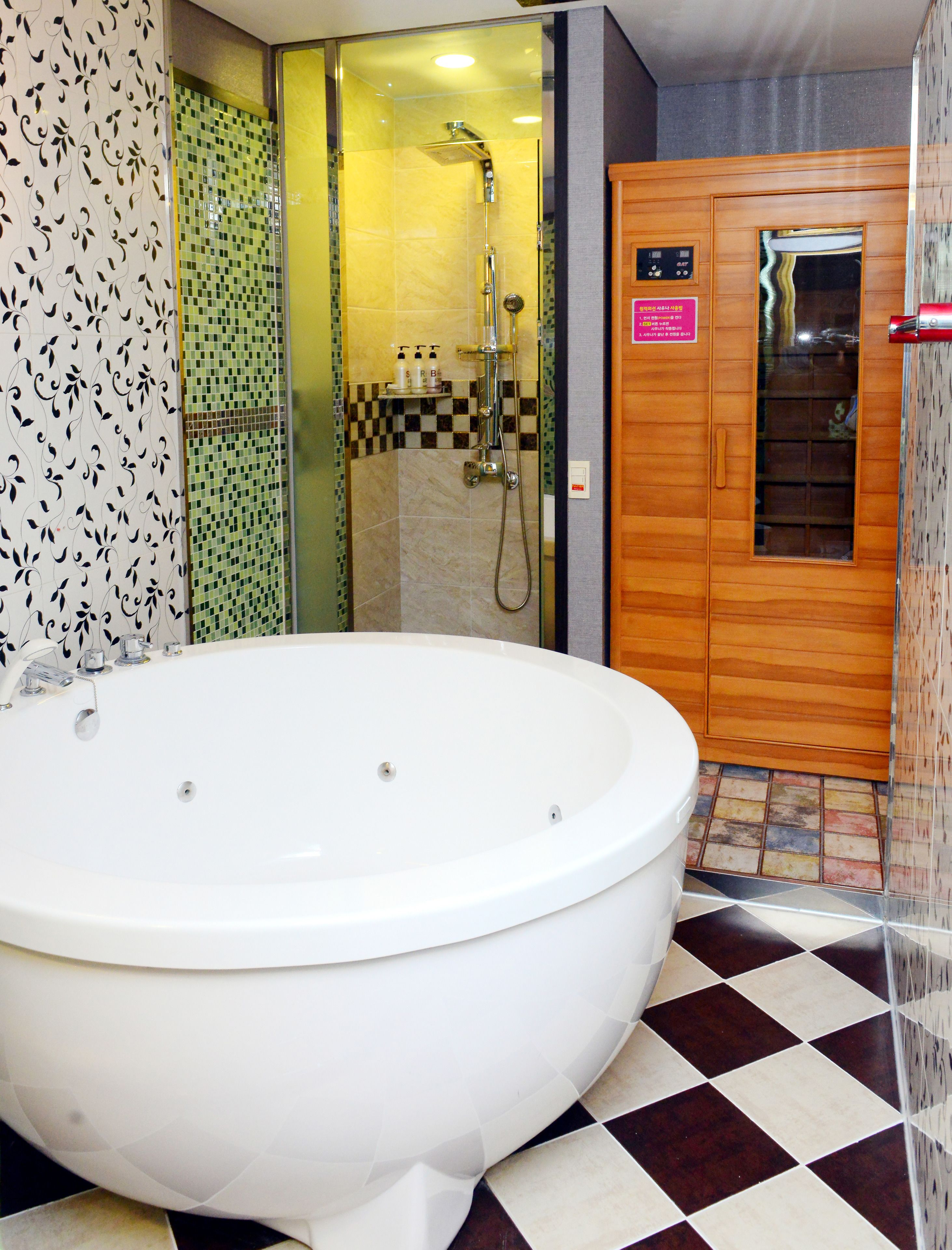 A bathroom with a large white bathtub, a shower area with a glass door, and a wooden cabinet with a mirror.