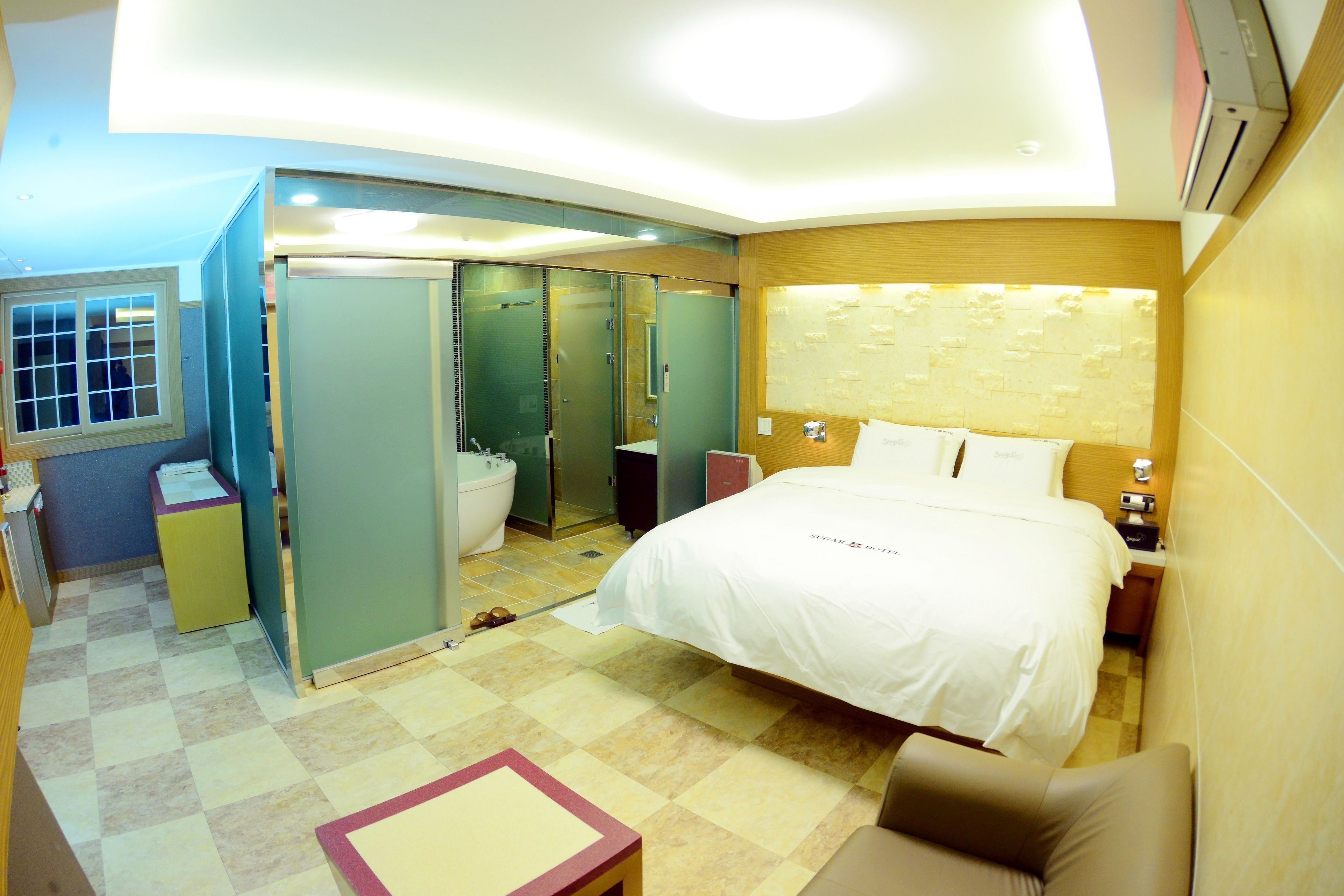 Een hotelkamer met een bed, een bureau, een stoel, een kledingkast en een badkamer.