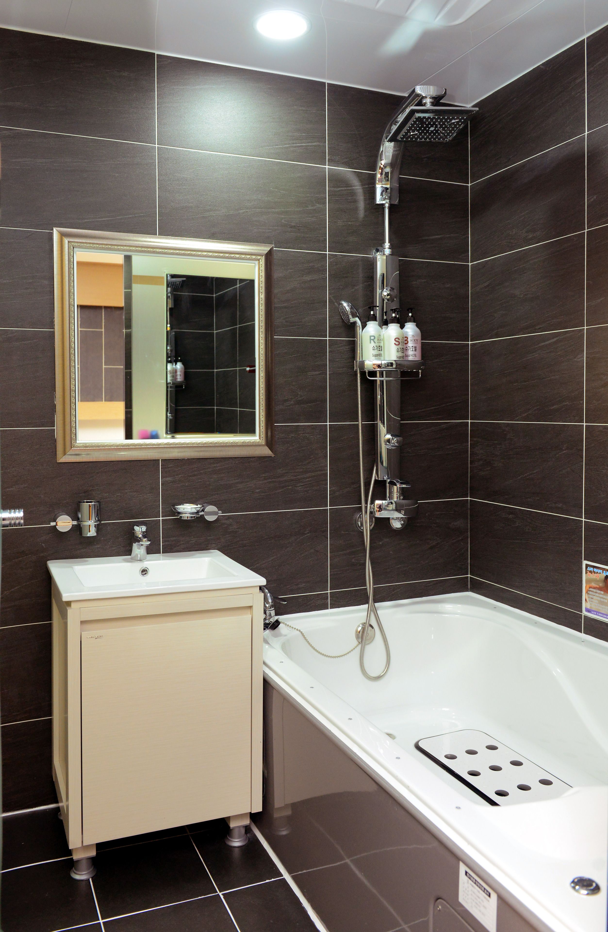 A modern bathroom with a bathtub, a sink, and a shower.