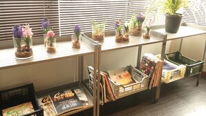 A shelf with small potted plants and books. - Daikoku House (Osaka)