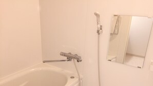 A bathroom with a bathtub, a shower, and a mirror. - Daikoku House (Osaka)