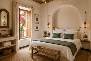 A bedroom with a large bed, a bedside table, a nightstand, a window with curtains, a mirror, and wall-mounted lights. - Riad Scarlett (Marrakech)