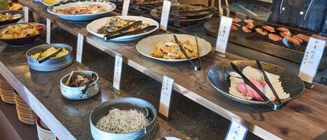 A buffet with various dishes and food items.