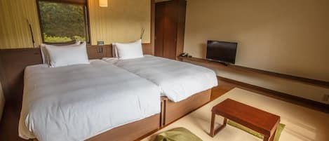 Una habitación de hotel con una cama grande, un televisor y una pequeña mesa de madera.