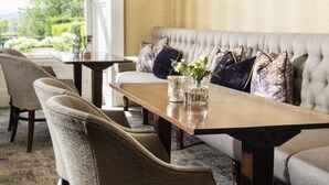 A cozy seating area with a sofa and chairs, a wooden table, and decorative pillows.
