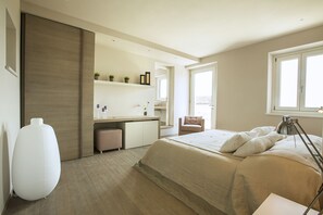 Una camera da letto moderna con un letto grande, un comodino e un angolo studio con scaffalature.