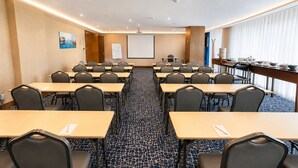 A conference room with multiple tables and chairs, a whiteboard, and a projector screen. - Nearport Hotel Sabiha Gokcen Airport (Istanbul)