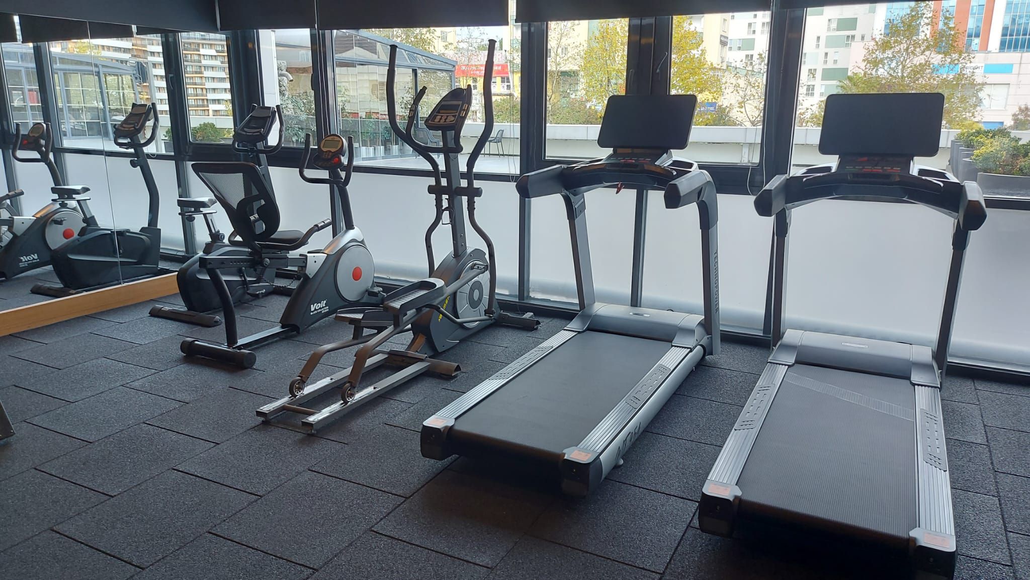 Ein Fitnessstudio mit Laufbändern, Ergometer und Rudergerät.