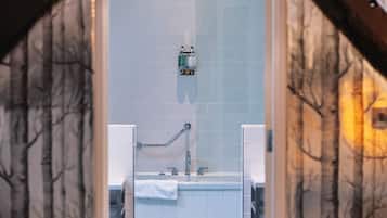 A bathroom with a white tiled wall, a sink, and a mirror.