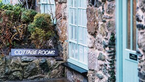 A stone building with a sign reading "COTTAGE ROOMS." - The Bull and Townhouse, Beaumaris- The Inn Collection Group (Beaumaris)