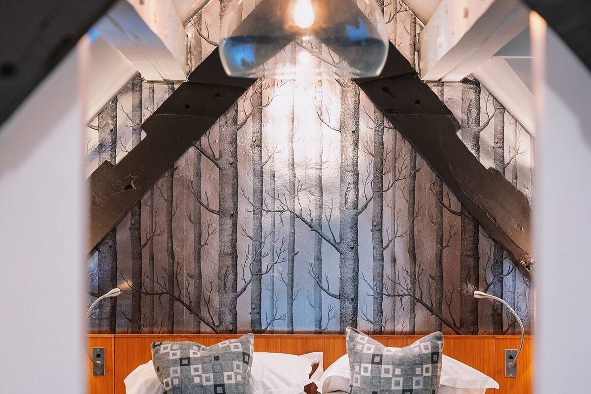 A bedroom with a bed, pillows, and a headboard.