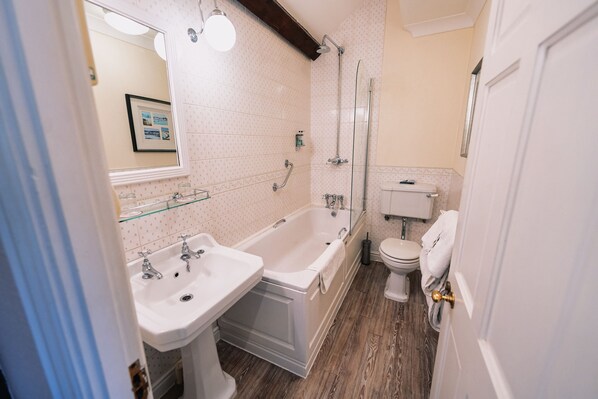 A bathroom with a bathtub, two sinks, a toilet, and a shower.