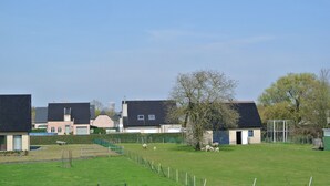 Un quartier résidentiel avec des maisons, une cour clôturée et un arbre.