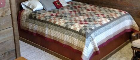A cozy room with a wooden bed, a small table with a decorative item, and a star decoration on the wall.