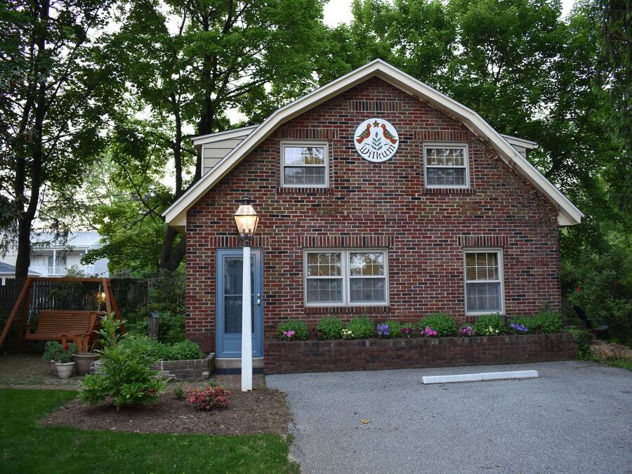 A brick building with a blue door, windows, and a logo on the front.