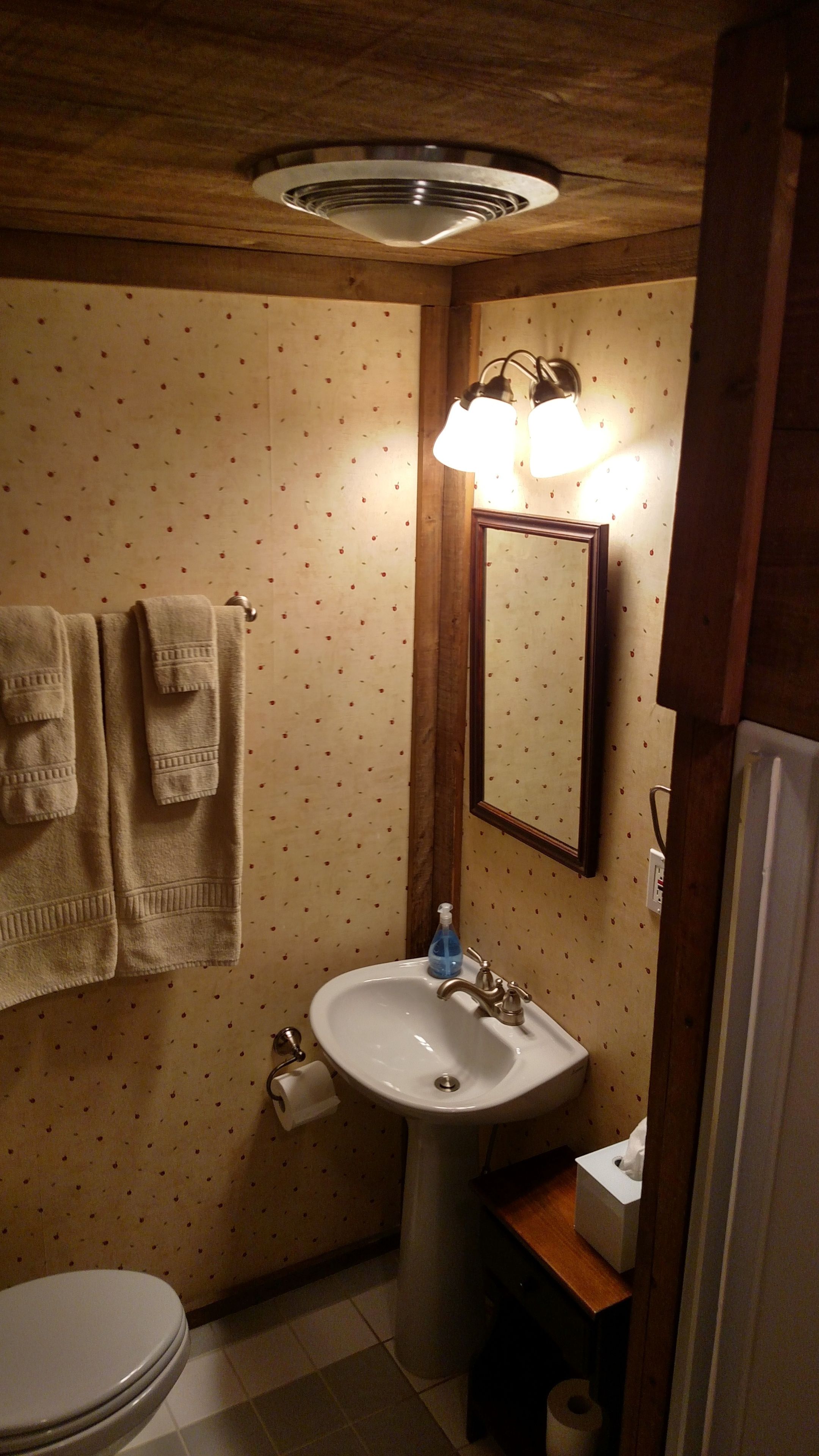 A bathroom with a toilet, sink, and towel rack.
