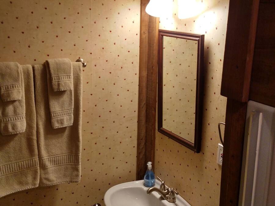 A bathroom with a toilet, sink, and towel rack.