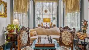 Una sala de estar de estilo antiguo con un sofá, una mesa de centro de vidrio y una lámpara.
