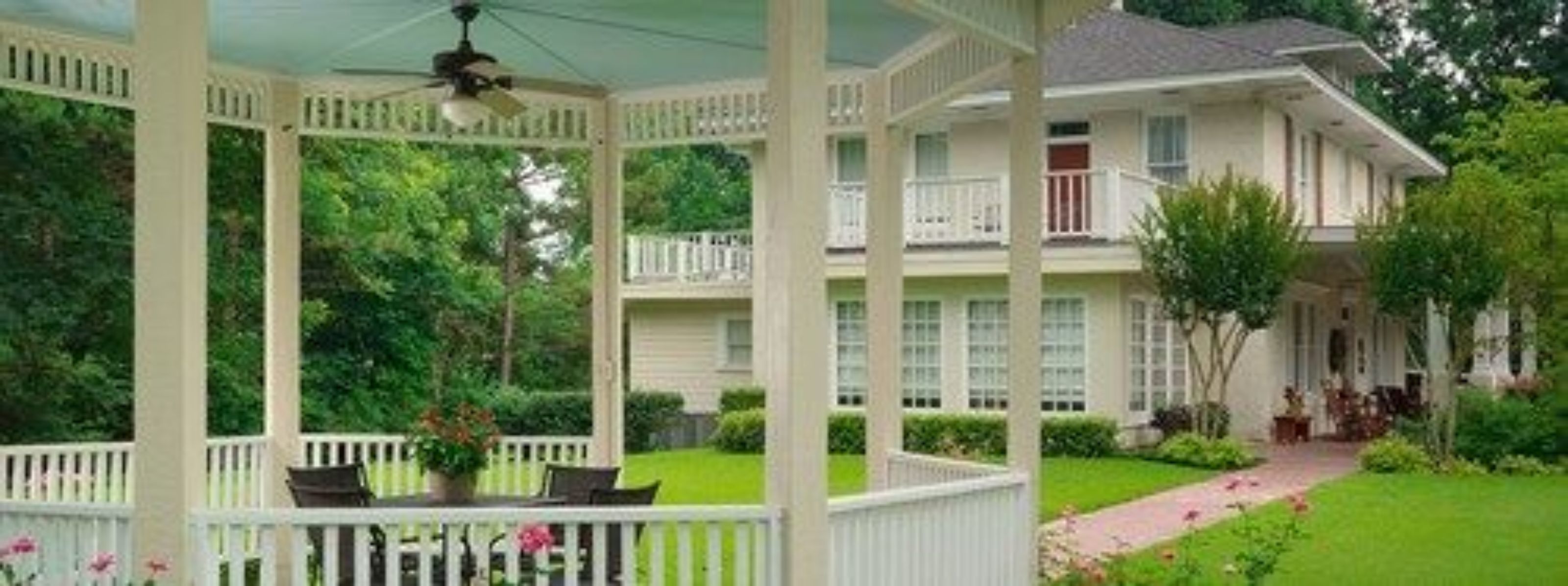 A two-story house with a covered porch and a well-maintained garden.