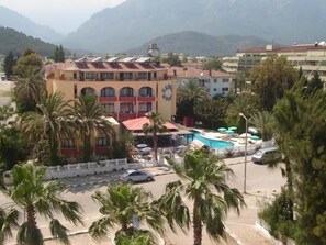 A hotel with a central courtyard, palm trees, and a swimming pool.