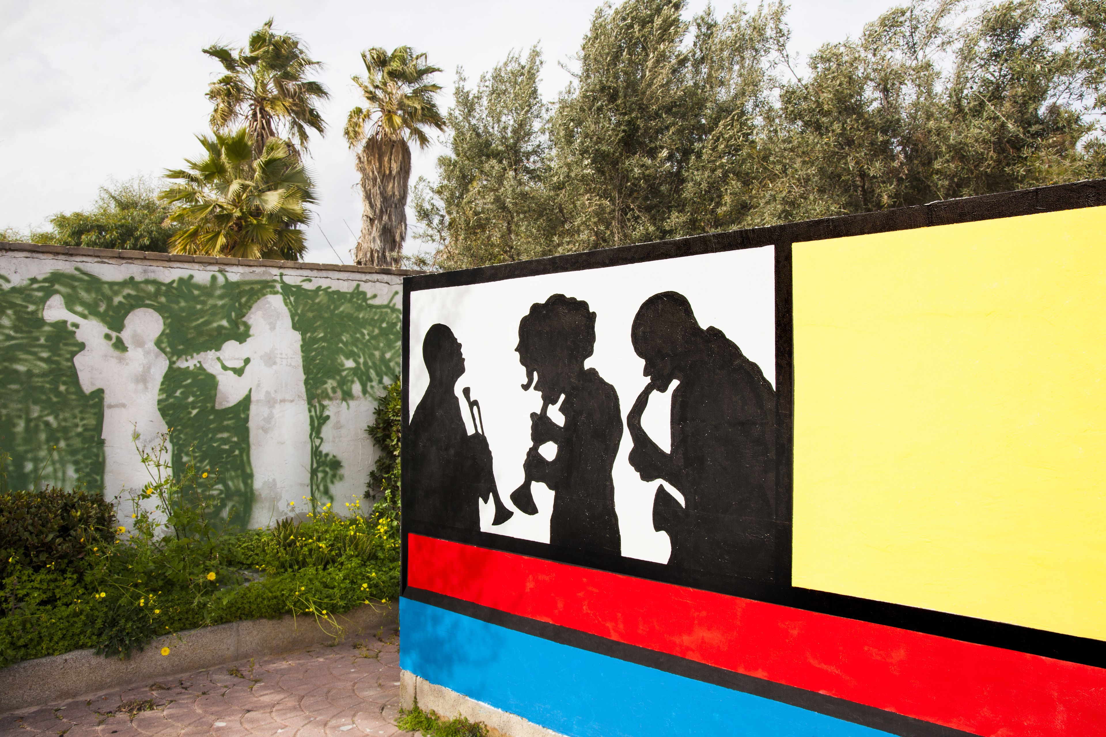 A colorful mural with silhouettes of people on a wall.