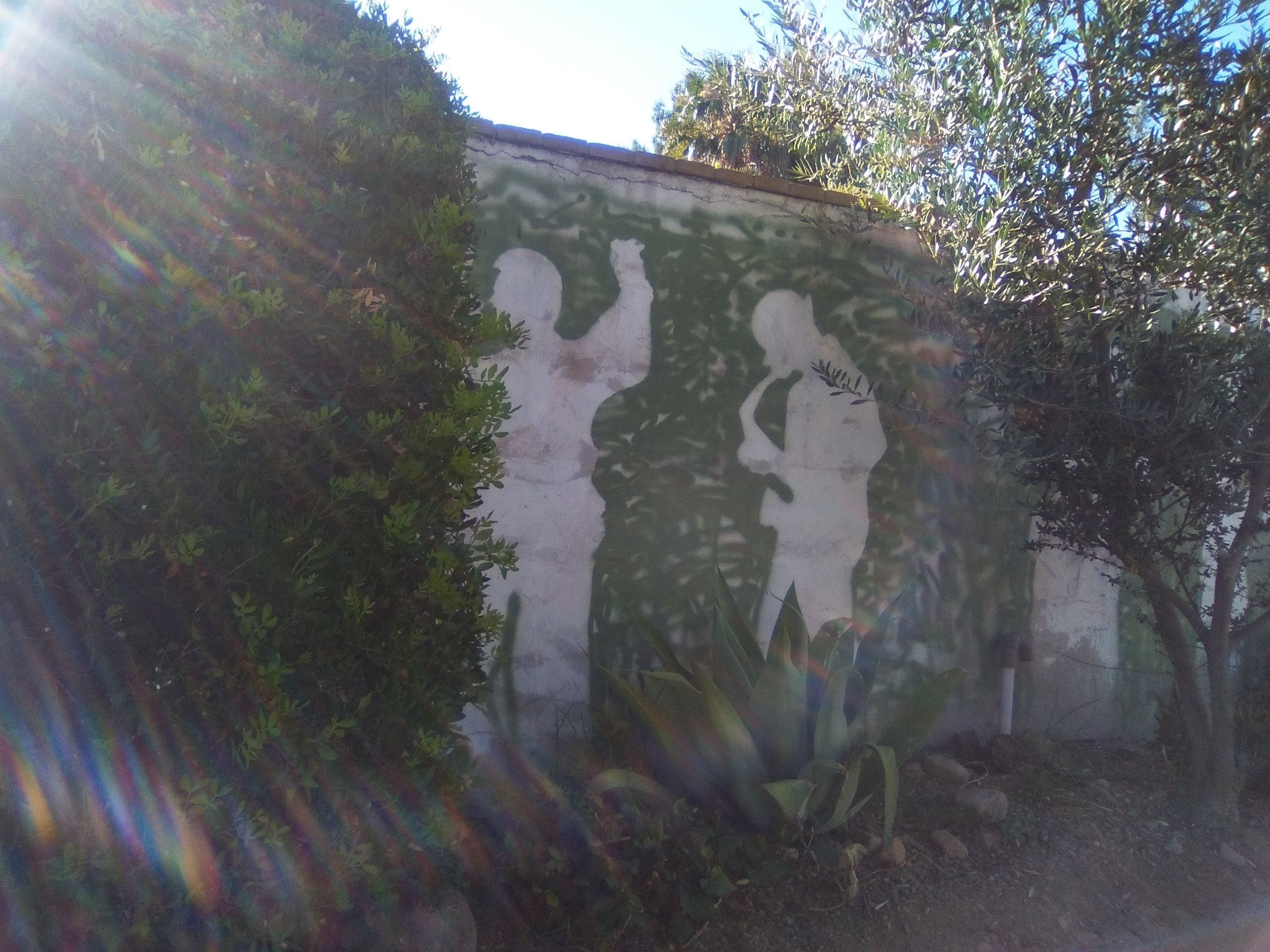 Una pared con un mural de dos figuras.