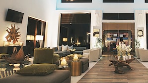Un salon spacieux doté d’un haut plafond, de grandes fenêtres et d’un design moderne.