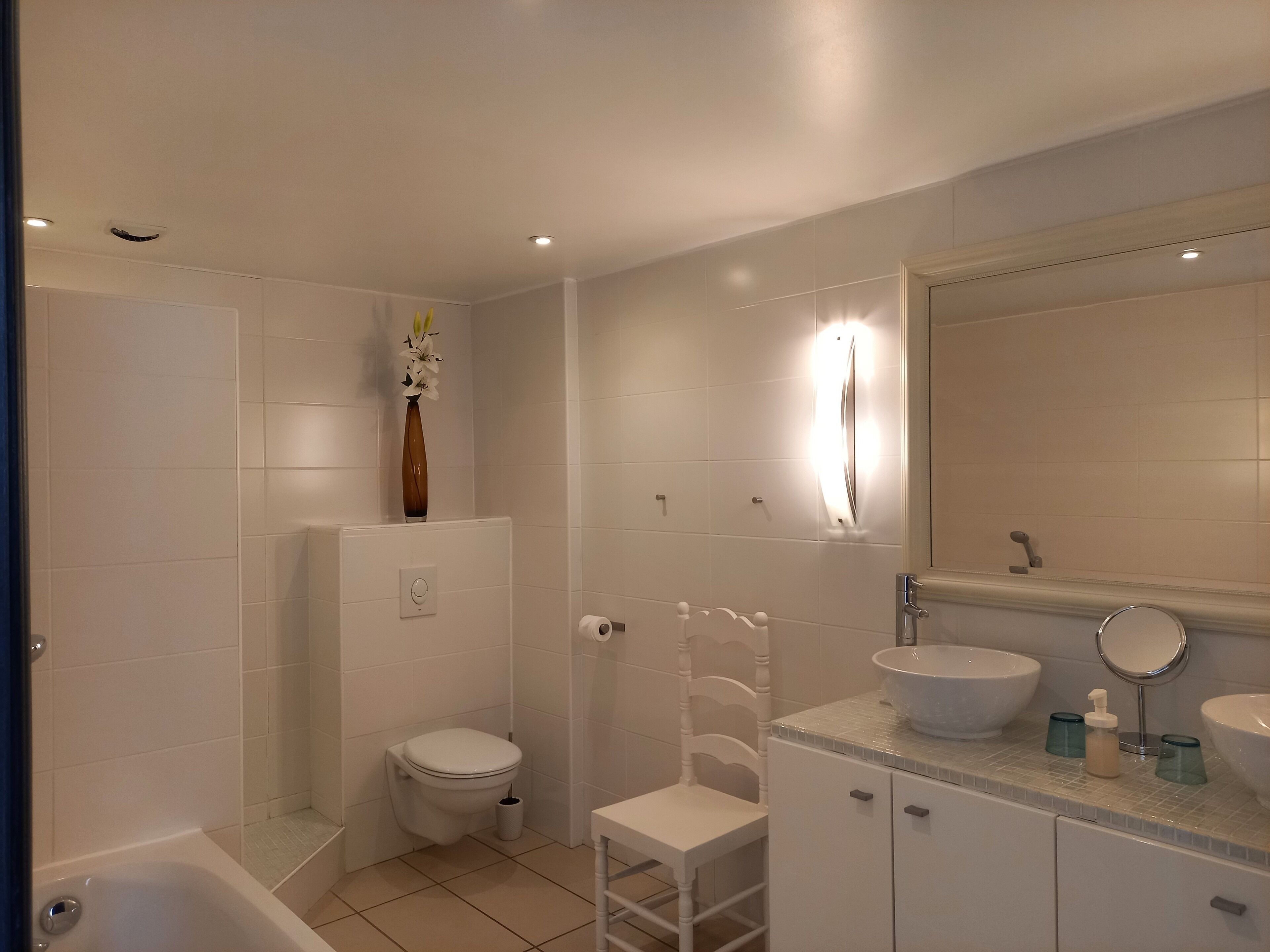 A modern bathroom with a toilet, shower, and sink area.