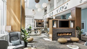 Un hall amplio con chimenea, asientos cómodos y una gran pantalla de televisión.