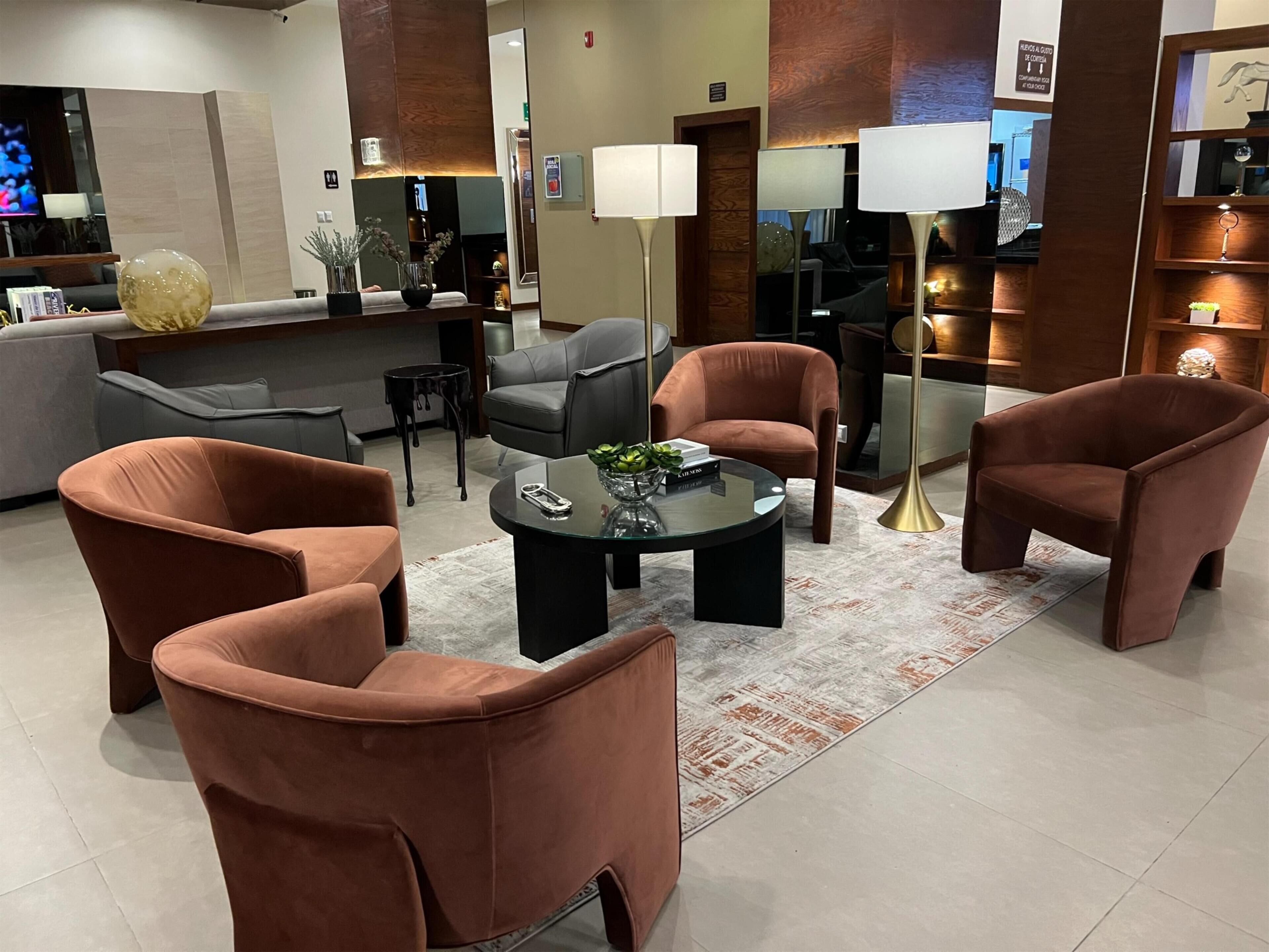 A modern living room with a sofa, armchairs, and a coffee table.