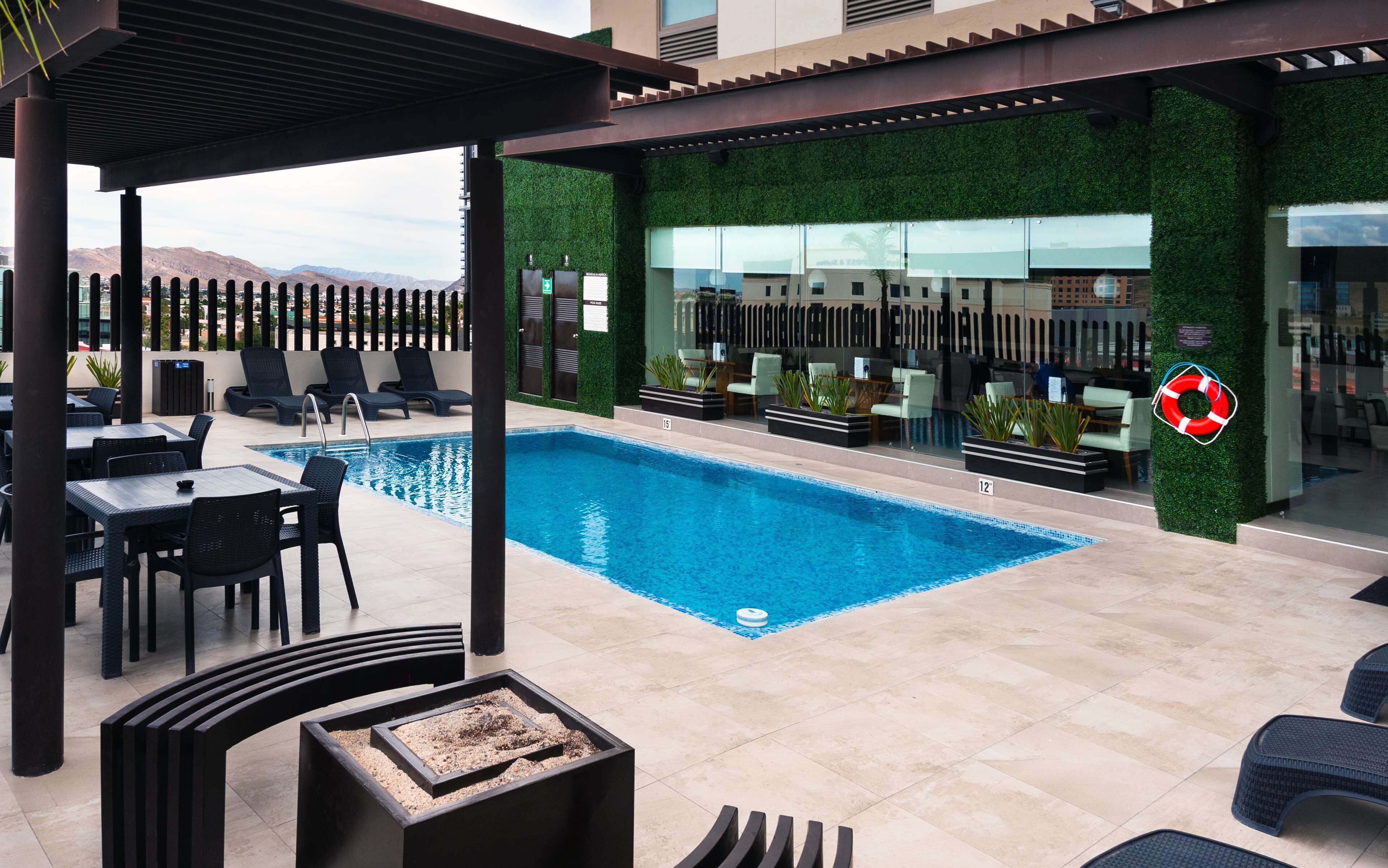 Alberca al aire libre y camastros 