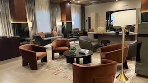 Una sala moderna con sofás, sillones y una mesa de centro.
