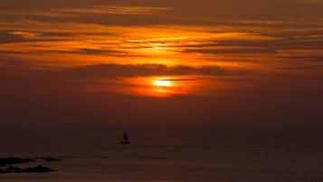 Un atardecer sobre el océano con un velero.