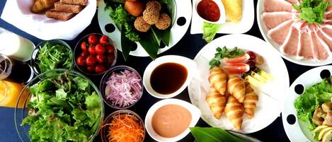 A variety of food items including croissants, meat, and vegetables on a table.